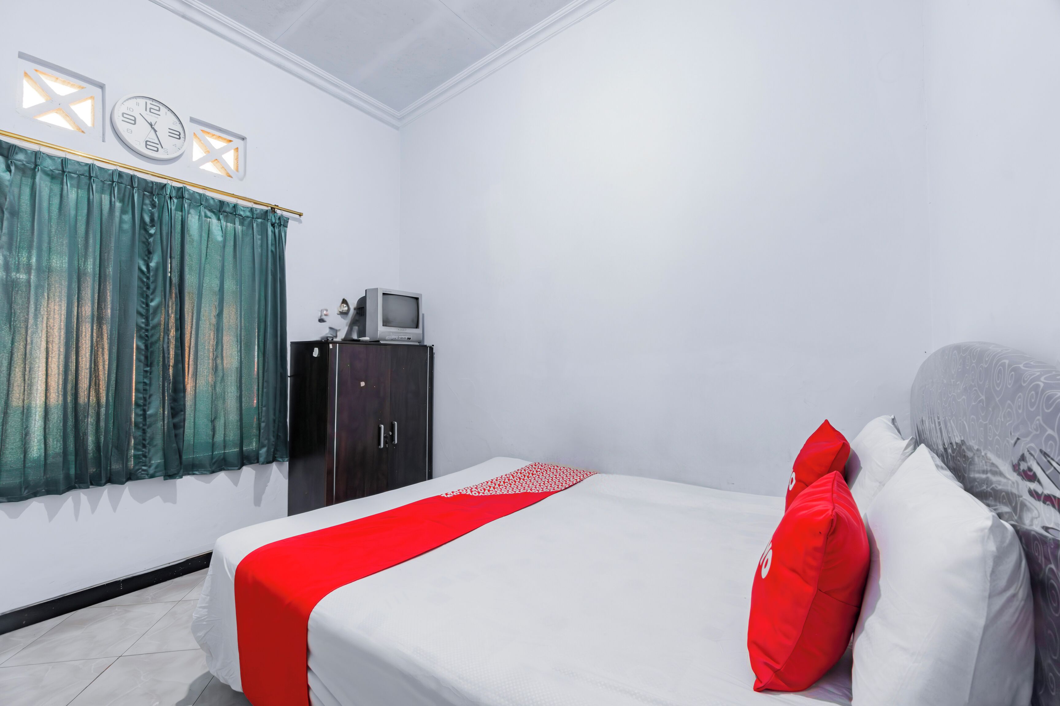 A hotel room with a bed, a TV, and a wardrobe.