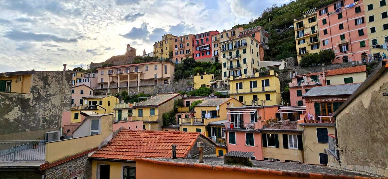 Un quartier résidentiel situé sur une colline, avec des bâtiments aux couleurs vives, dont certains sont dotés de balcons et de terrasses.