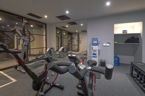 A gym with cardio machines, a water dispenser, and a towel rack. - King Street Aparthotel (Stirling)