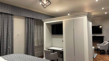 Ein modernes Schlafzimmer mit Bett, Schreibtisch, Kleiderschrank und Fernseher.