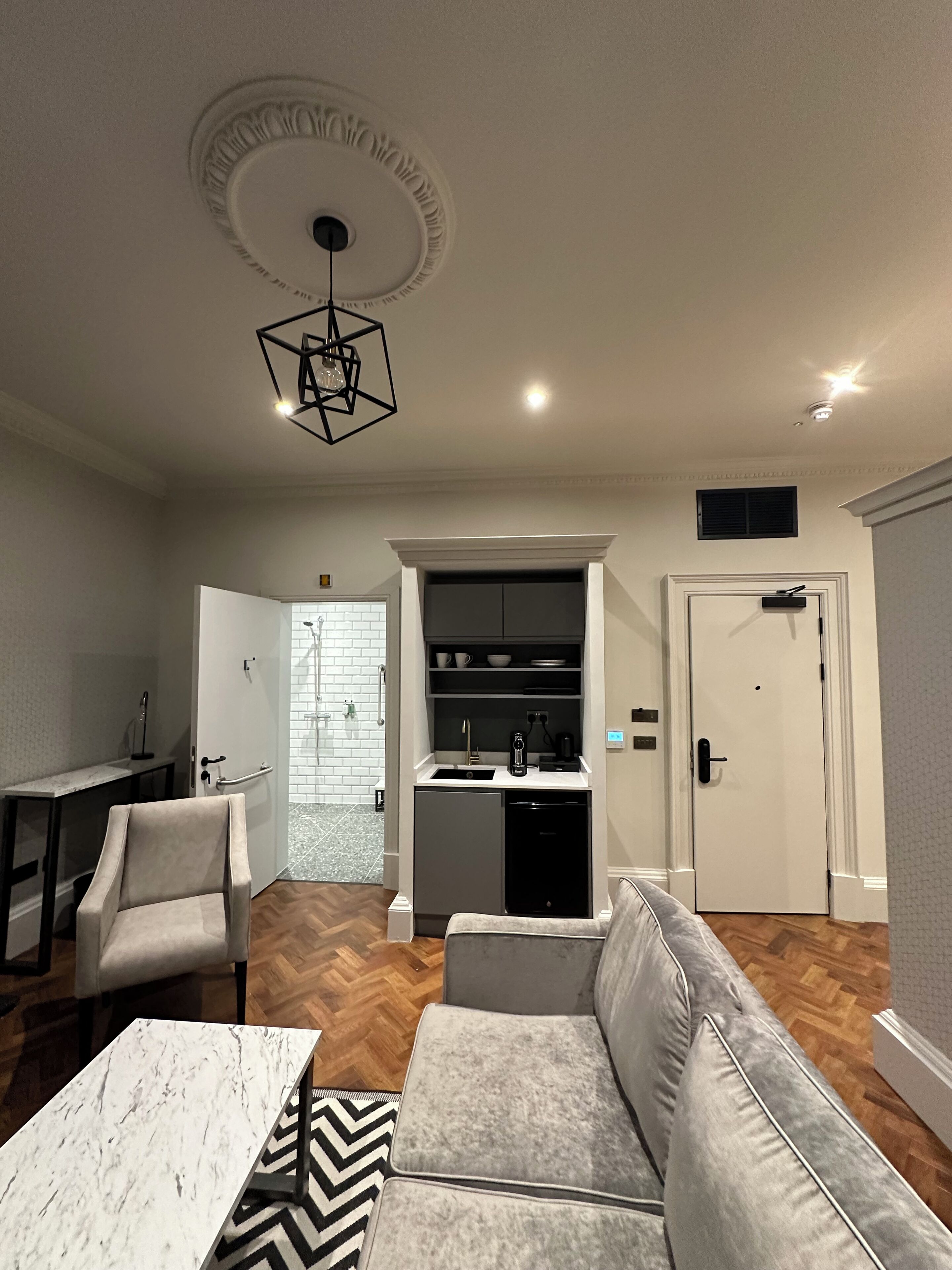 A modern living room with a sofa, a coffee table, and a dining area with a table and chairs.