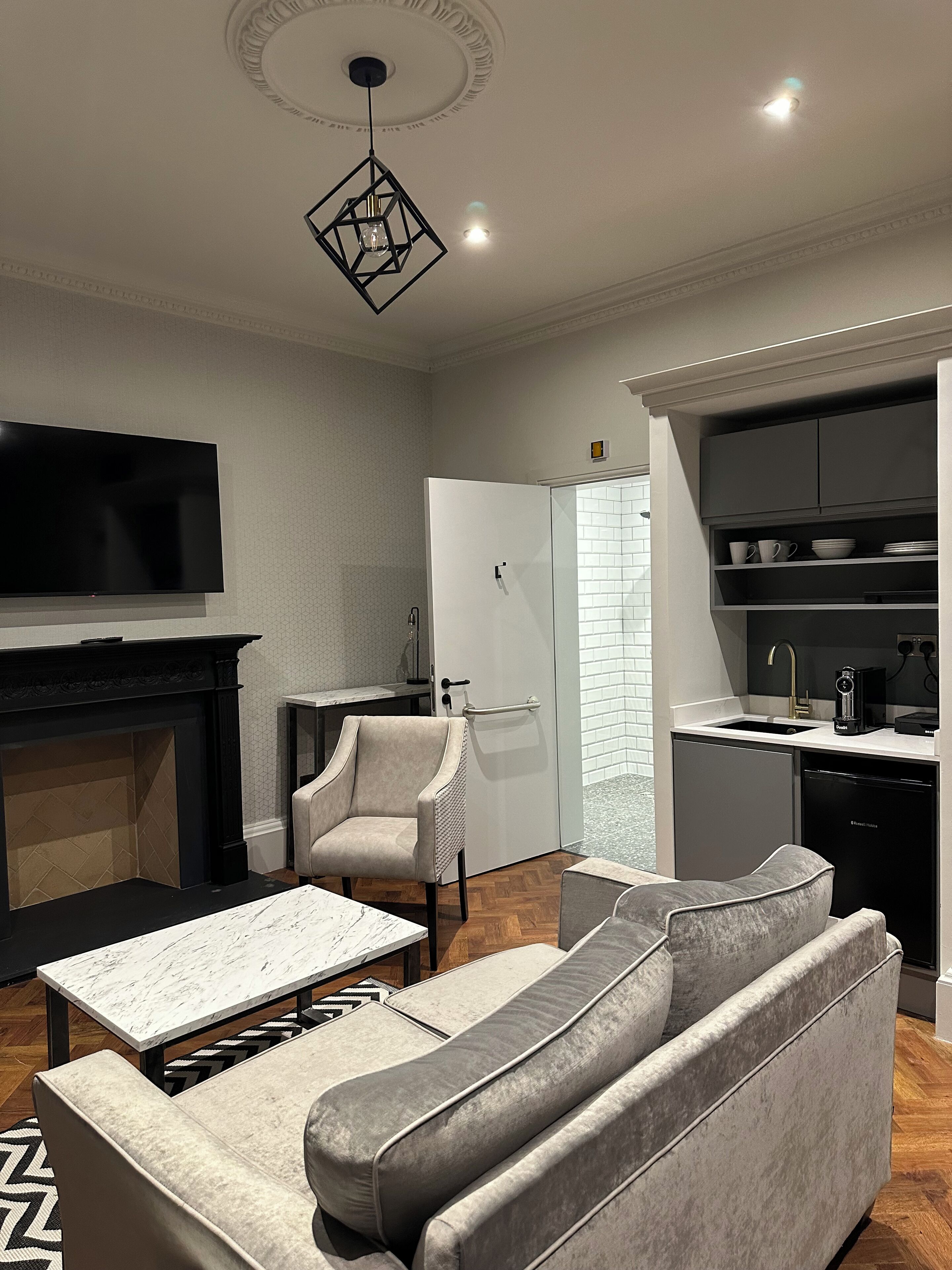 A modern living room with a fireplace, sofa, and TV.