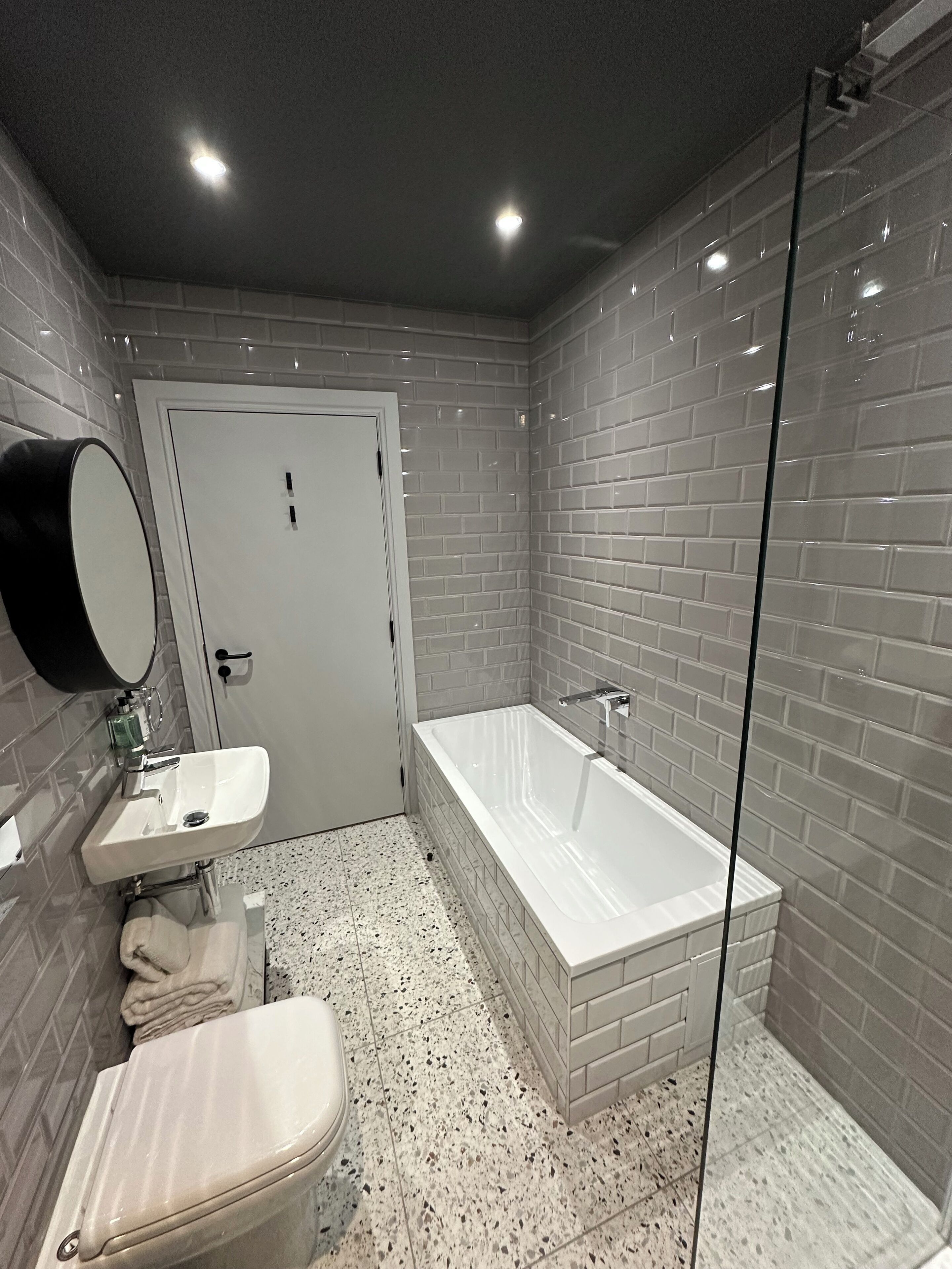 Ein modernes Badezimmer mit einer weißen Badewanne, einem Waschbecken und einer Toilette.