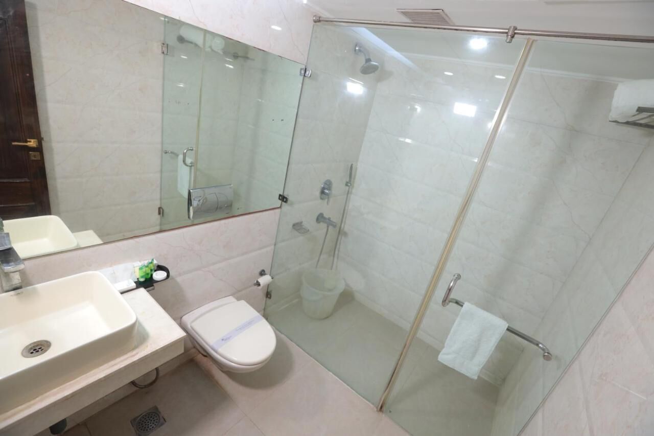 Une salle de bain moderne avec une douche à parois de verre, des toilettes et un lavabo.
