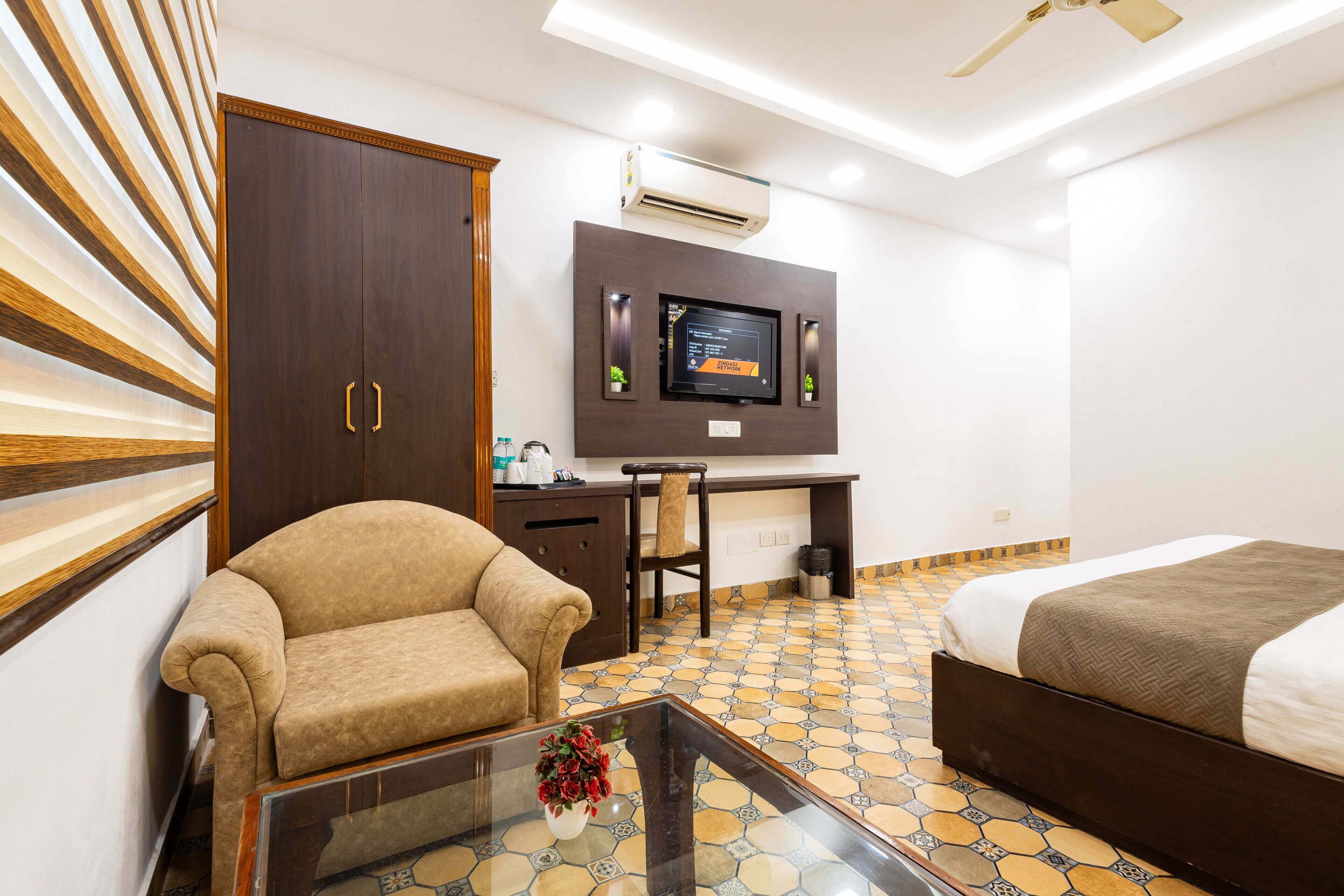 Una habitación de hotel con una cama, un sofá, un escritorio y un televisor.
