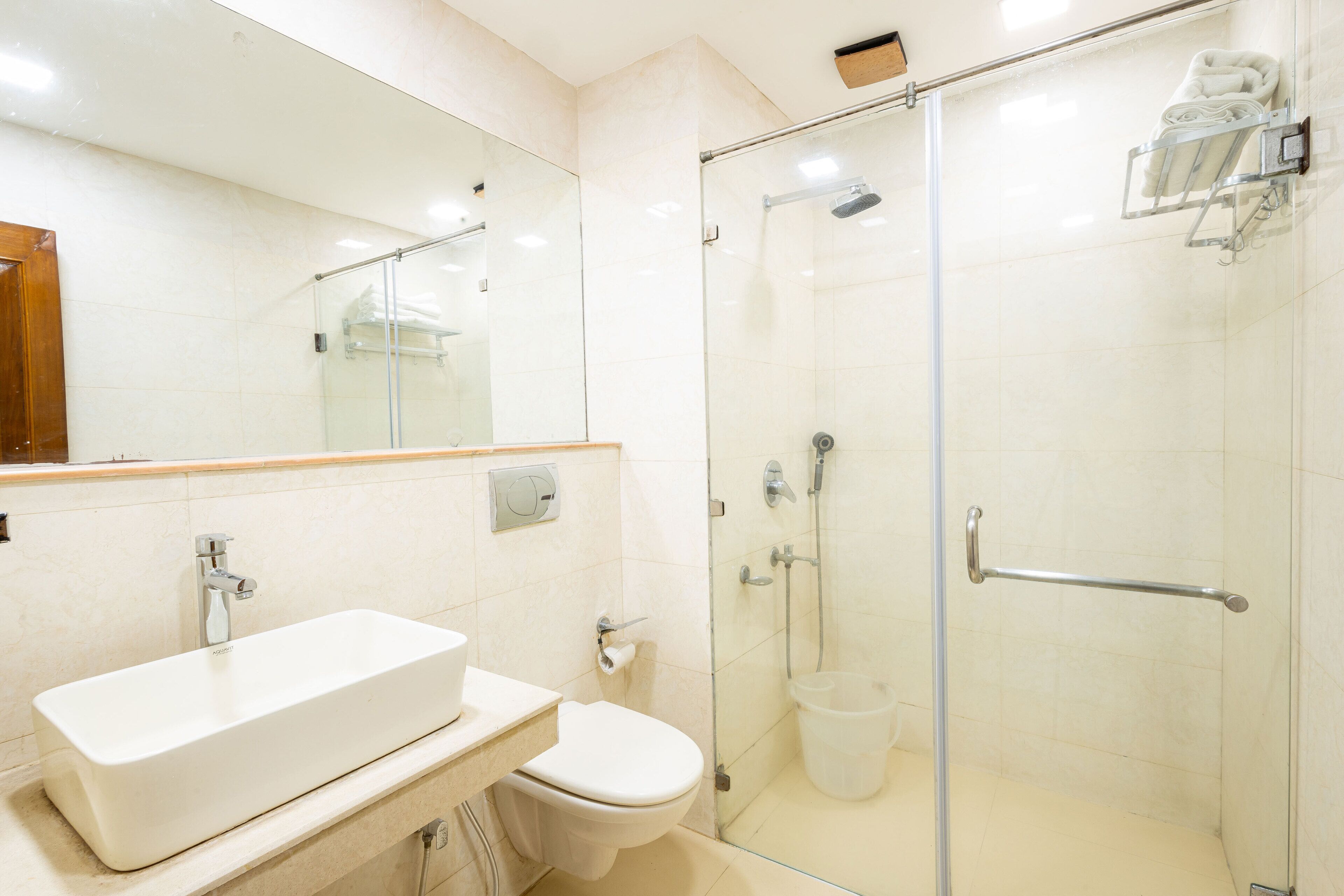 A modern bathroom with a glass-enclosed shower, a white sink, and a toilet.