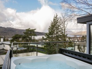 A hot tub on a balcony overlooking a lake, trees, and a mountainous landscape. - Detached 4 Bed Home, Hot Tub & Lake View - Pets OK (Bowness-on-Windermere)