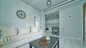 Een moderne woonkamer met een bank, een salontafel en een keuken op de achtergrond.