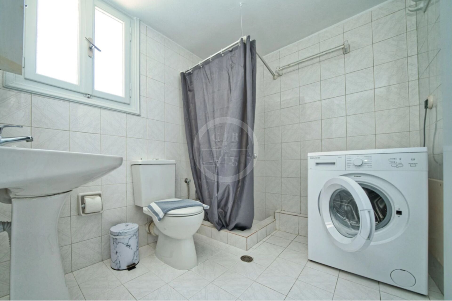 Un baño con inodoro, lavadora y lavamanos.