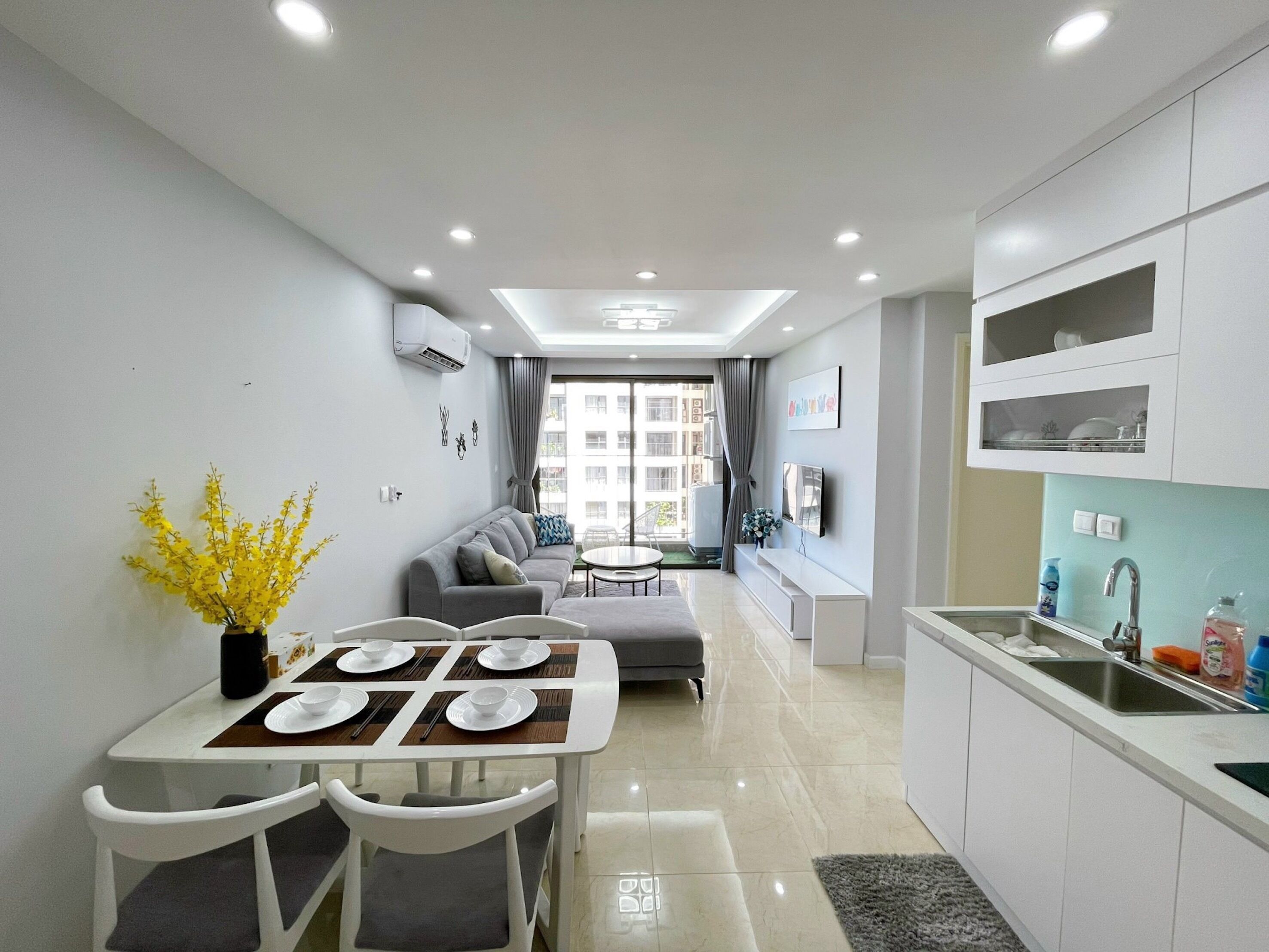 A modern apartment with a dining area, kitchen, and living space.