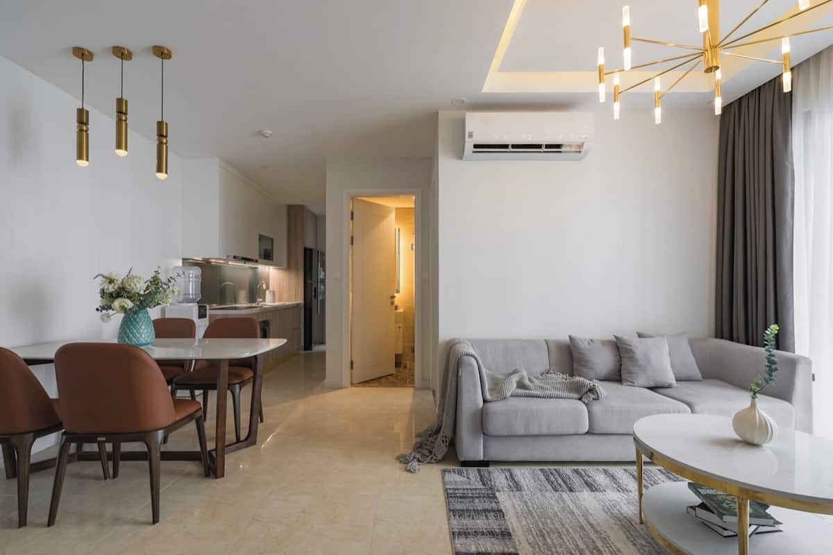 A modern living room with a sofa, coffee table, and dining area.
