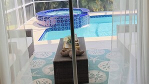 Una stanza con pareti vetrate e vista su una piscina e una vasca idromassaggio.