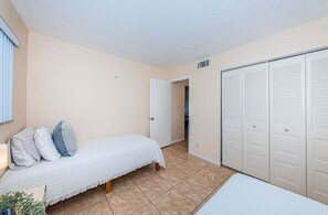 Una camera da letto con un letto, un armadio e una porta che dà su un'altra stanza.