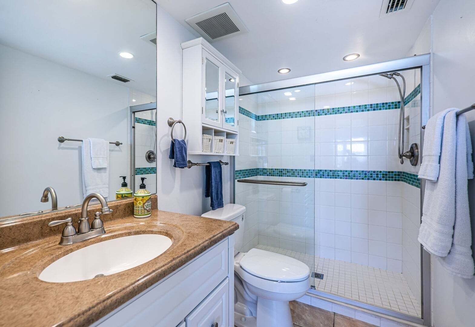 Un baño con lavamanos, inodoro y ducha.
