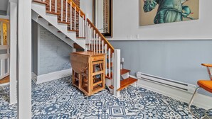 A staircase with wooden steps and white railings, a patterned floor, and a painting on the wall. - Elegant Victoria 2BR 1.5BA & Private Yard (St. John's)