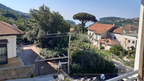 Um bairro residencial com casas, uma árvore imponente e céu claro.