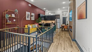 Un intérieur moderne avec un escalier, un canapé jaune, une cuisine et un coin repas.