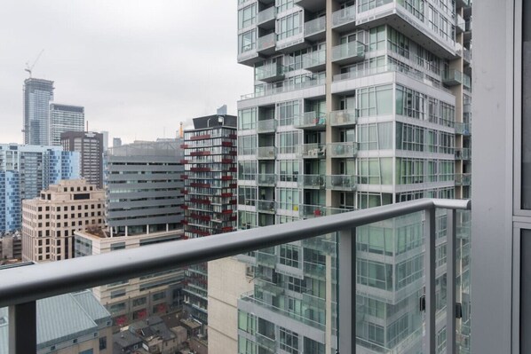 Un edificio moderno de gran altura con múltiples balcones y amplias ventanas.