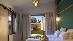 Une chambre à coucher avec un lit, des rideaux, une fenêtre et une vue sur l’extérieur.