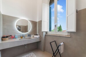 A bathroom with a large mirror, a window with curtains, a towel rack, and a decorative starfish. - Villa Vallone Luxury With Pool (Galatina)