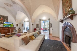 Un salón amplio con un techo abovedado, una chimenea y un televisor.