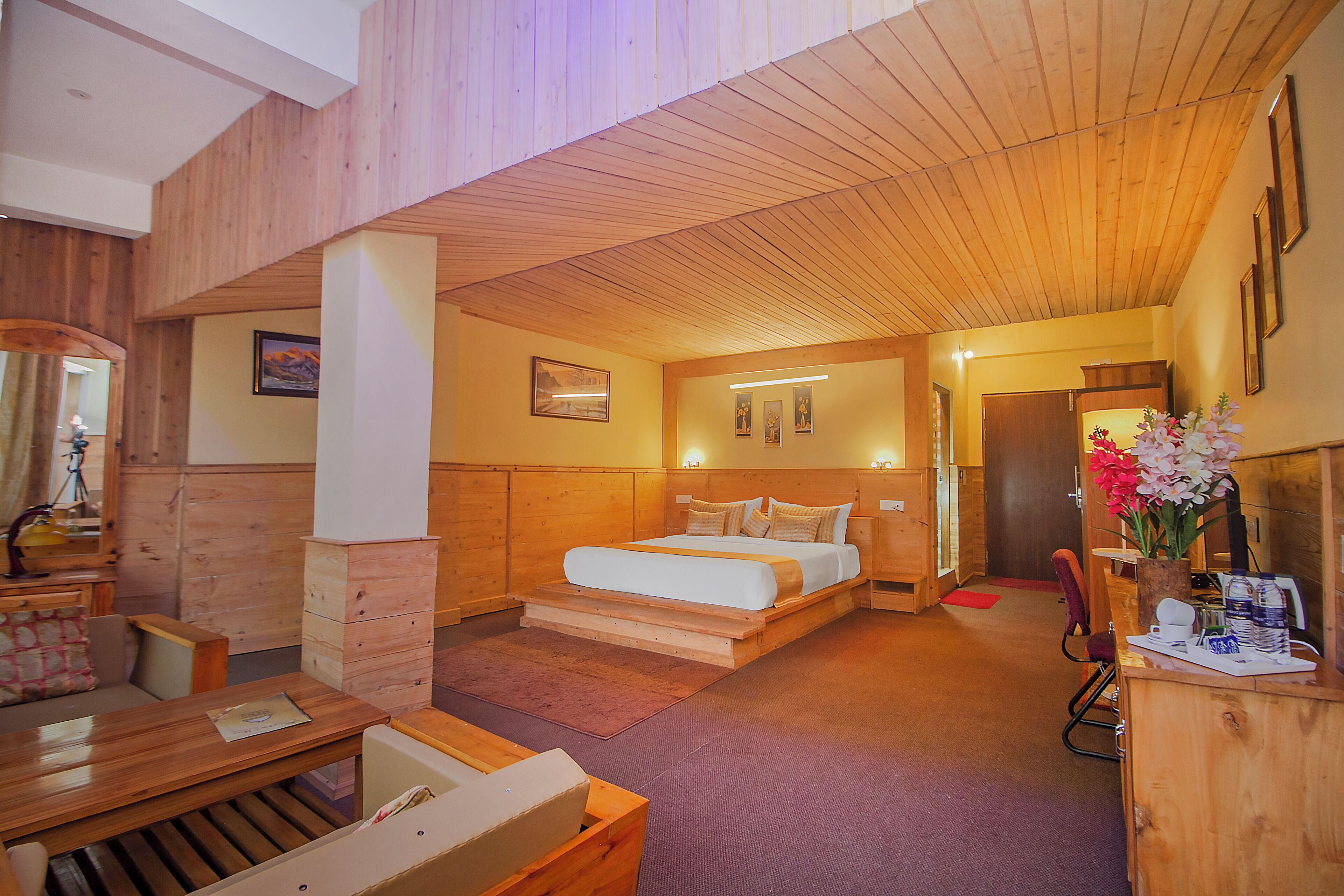 Un interior de madera con cama, escritorio y zona de estar.