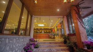 Fachada de hotel de madera, con amplias ventanas y un mostrador de recepción.