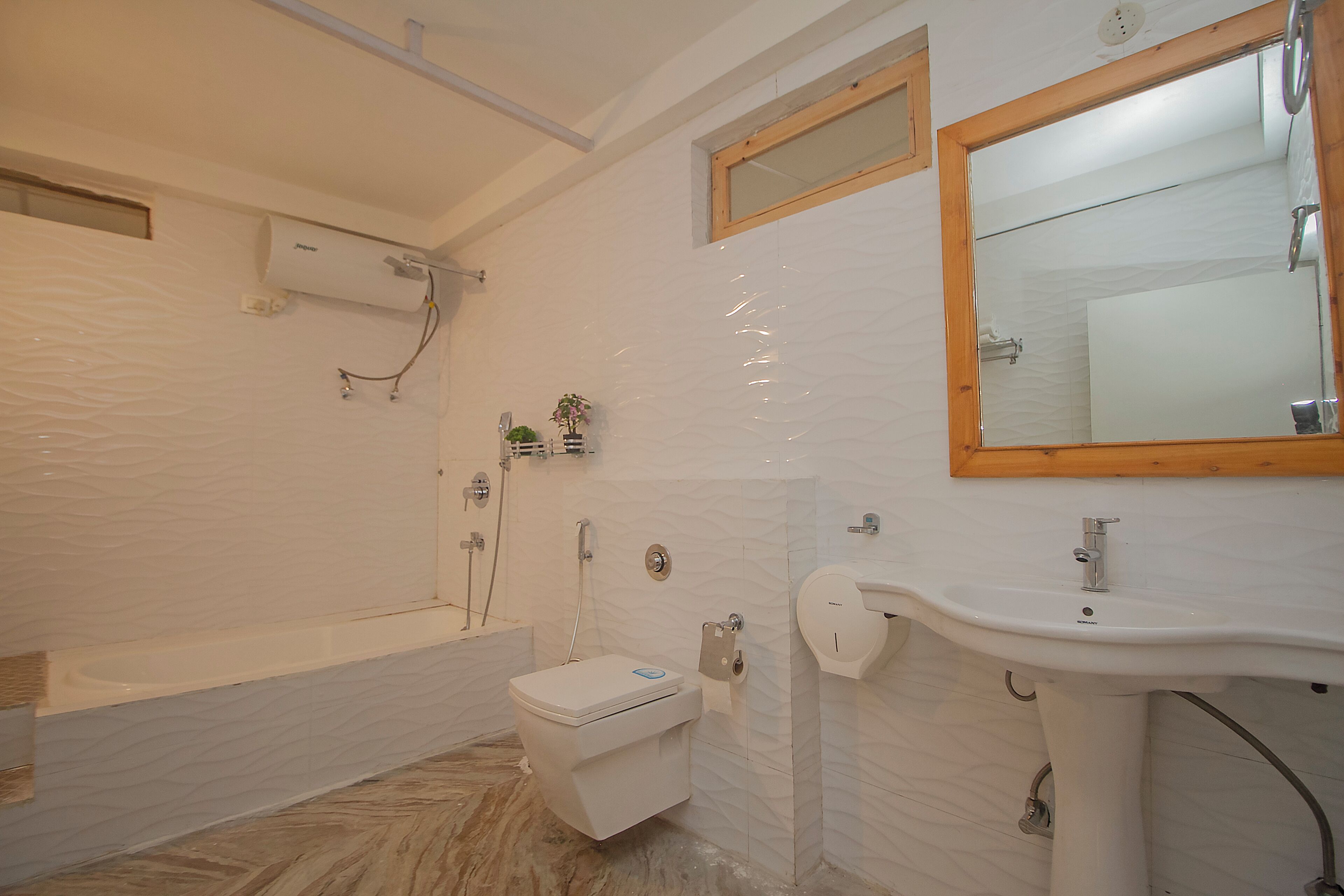 A bathroom with a bathtub, toilet, sink, and a mirror.