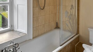 A bathroom with a bathtub, a shower enclosure, and a toilet. - A quirky 2-bedroom town house just out of the centre of Tain. (Tain)