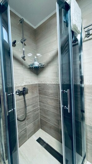 Vierpersoonskamer | Badkamer | Een douche, een haardroger, handdoeken, zeep