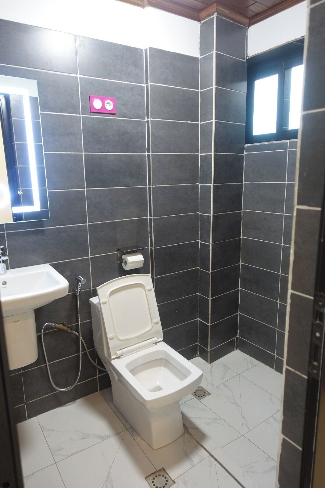 Un baño pequeño con inodoro, lavamanos y espejo.
