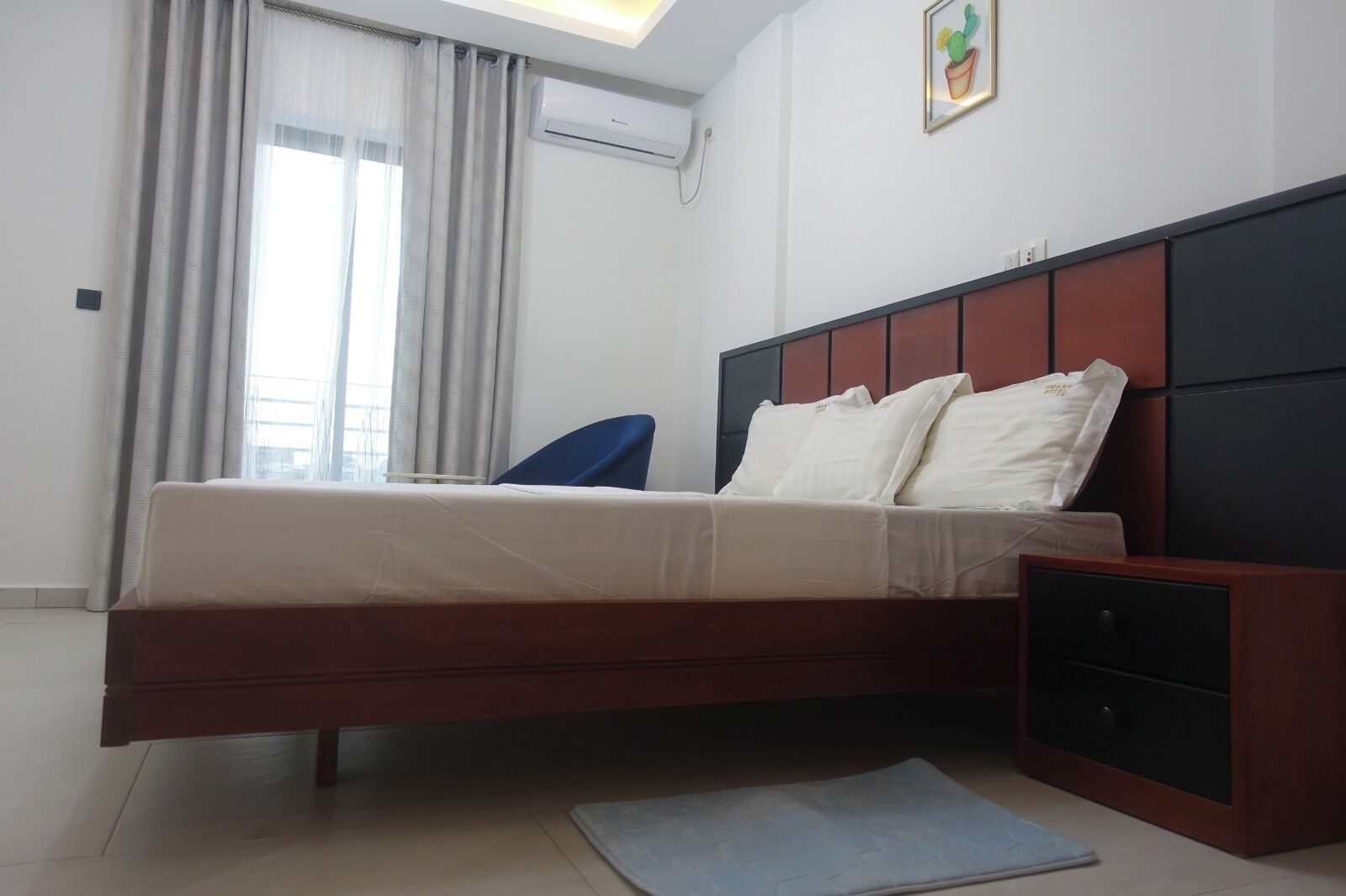 Ein modernes Schlafzimmer mit Bett, Nachttisch und einem Fenster mit Vorhängen.
