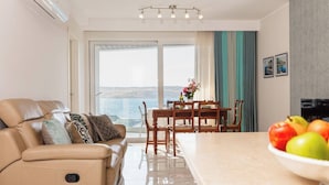 Una sala de estar moderna con un sofá de cuero, una mesa de comedor y vistas al mar.