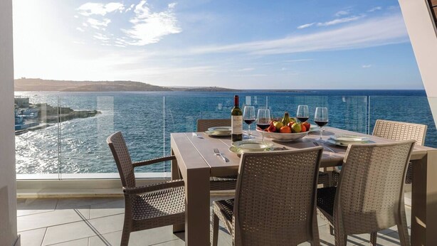 Mesa lista para comer con vista al mar y a la costa distante.