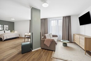 Relax in a spacious room with a large bed, sofa, and flat-screen TV.
