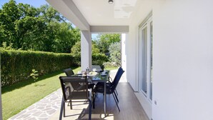 An outdoor patio with a table and chairs, surrounded by a stone pathway and a well-maintained hedge. - Villa Mares 1 with shared pool in a quiet village near Umag (Cepljani)