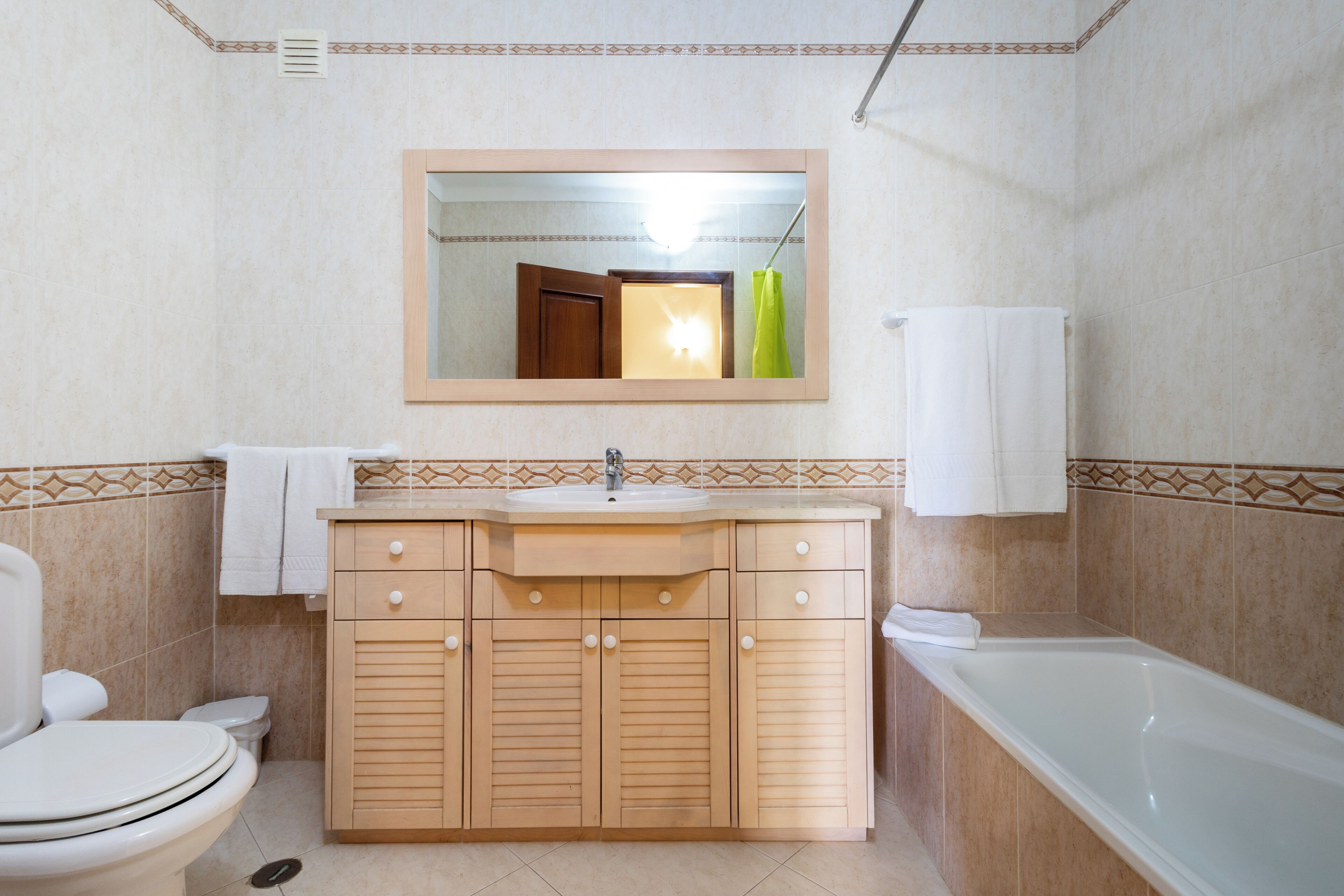 Un baño con inodoro, lavamanos, tocador y bañera.