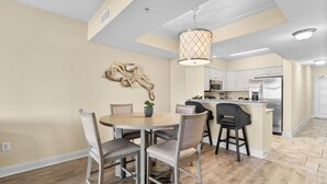 A modern kitchen with white cabinets, stainless steel appliances, and a central island. - Beachfront Paradise: Spacious 2BR Condo with Views (North Myrtle Beach)
