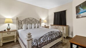 A neatly arranged bedroom with a bed, bedside tables, and a nightstand.