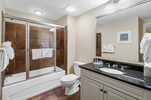 A modern bathroom with a glass-enclosed shower, a white toilet, and a vanity with a sink. - Oceanfront Oasis: 2BR 2BA Condo with Stunning Views (North Myrtle Beach)