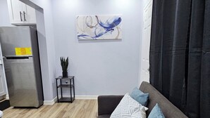 A modern living room with a grey sofa, a small side table, and a potted plant.
