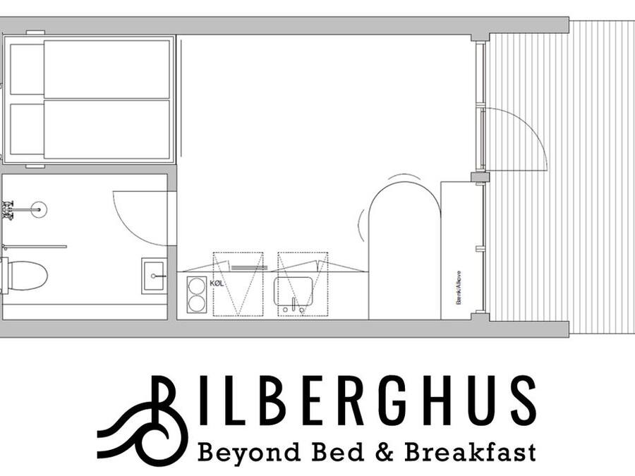 A hotel floor plan with a bathroom, kitchenette, and a large living area.