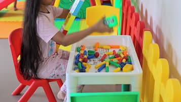 Children can play and learn with a variety of building blocks and a fun slide nearby.