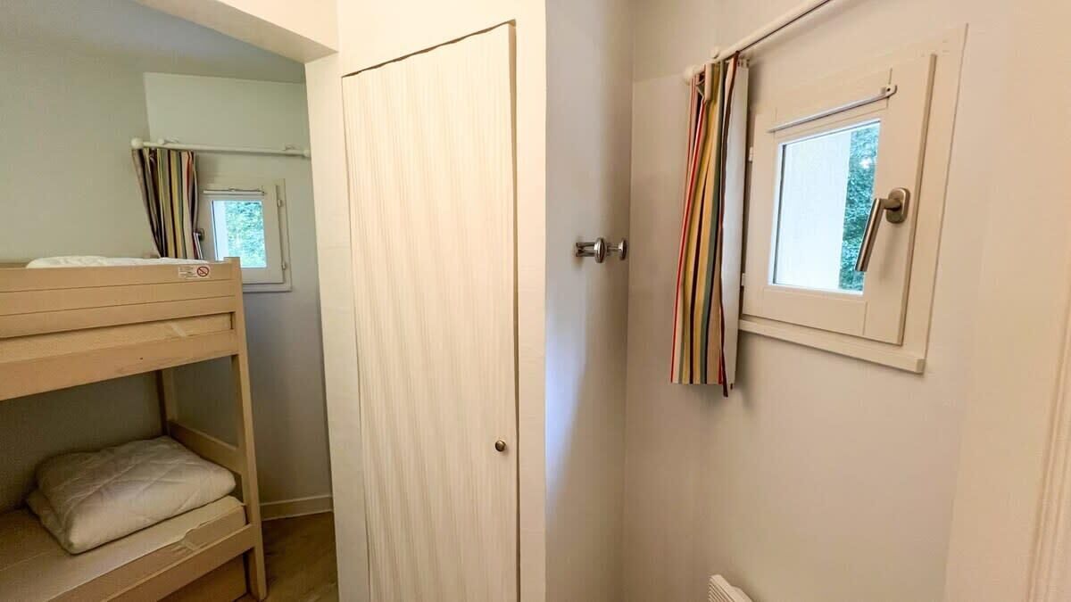 Et værelse med køjeseng, dør med et vindue og en radiator.