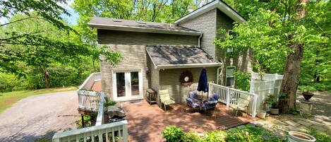 A two-story house with a deck, a covered patio, and a fenced yard.