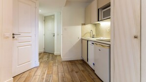 A compact kitchen with white cabinets, a microwave, and a dishwasher. - Appt pour 4 pers avec piscine couverte tennis et parking gratuit 227 (Le Touquet-Paris-Plage)