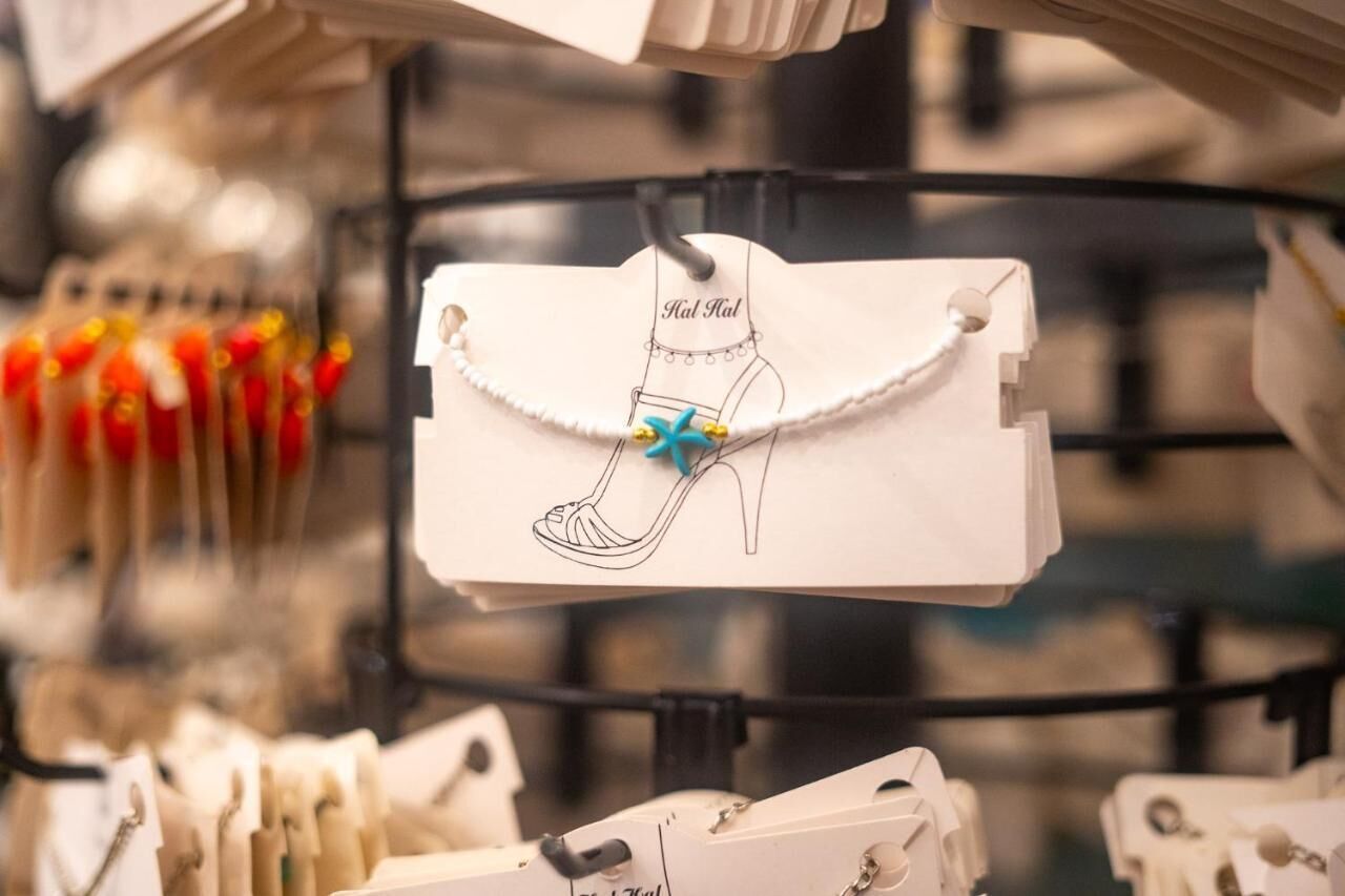 Une vitrine où sont exposés des bijoux, avec une étiquette suspendue à un présentoir.