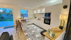 A modern kitchen with a large window, a microwave, an oven, and a sink. - Superb cottage for 4 people with views of the dunes (Merlimont)