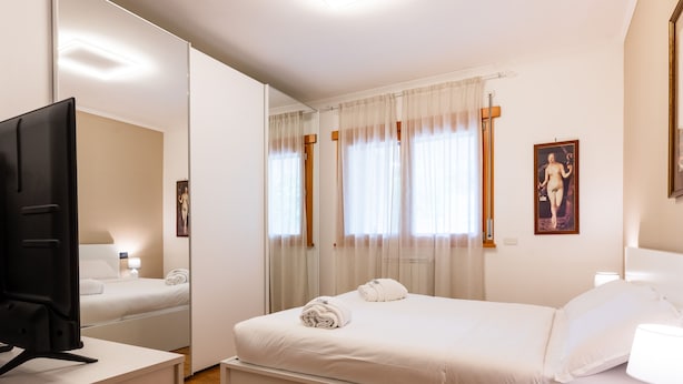 A hotel room with a bed, a desk, a television, and a window with curtains. - Bonum Vitae in Rome With 1 Bedrooms and 1 Bathrooms (Rome)