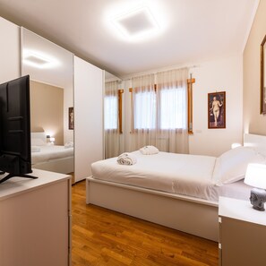 A hotel room with a bed, a desk, a television, and a window with curtains. - Bonum Vitae in Rome With 1 Bedrooms and 1 Bathrooms (Rome)